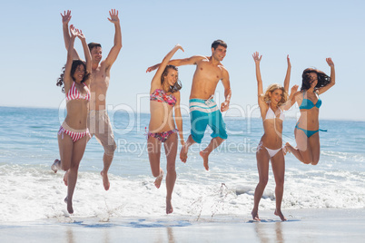 Happy friends jumping on the beach