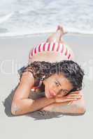 Brunette woman lying down on beach