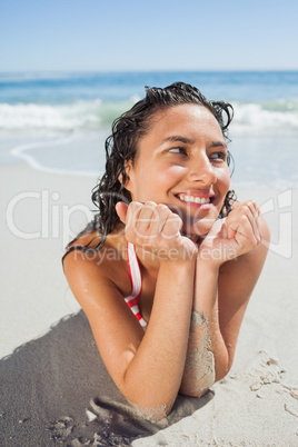 Close up view of smiling woman lying down on beach