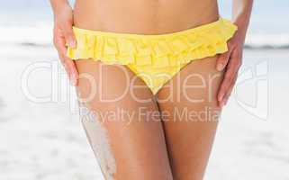 Mid section of fit woman in yellow bikini