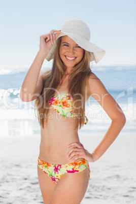 Young smiling woman in bikini standing with her hand on her hip