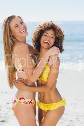 Two smiling friends hugging each other