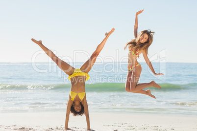 Friends in bikinis jumping and doing handstand