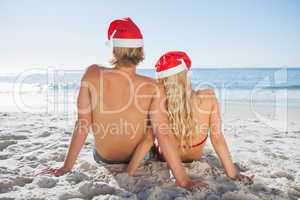 Rear view of couple sitting on beach
