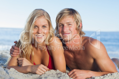 Smiling couple lying on the beach