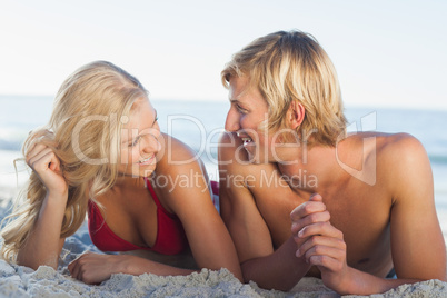 Smiling couple facing each other and lying