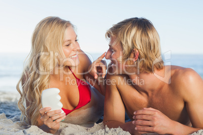 Woman putting sun cream on nose of her partner