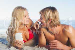 Woman putting sun cream on nose of her partner