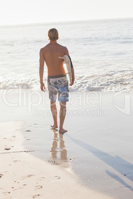 Rear view of man holding surfboard