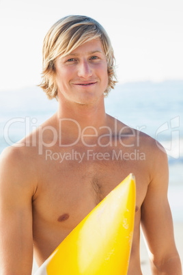 Handsome man with his surfboard at the beach