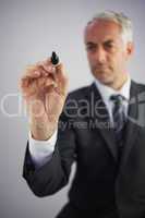 Serious businessman holding a marker and writing