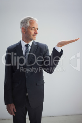 Unsmiling businessman presenting something