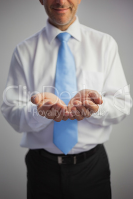 Close up of a pleased businessman joining his hands to the camer