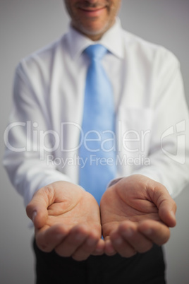 Close up of a content businessman joining his hands to the camer