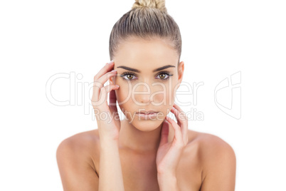 Cute woman holding her head and looking at camera
