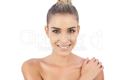 Smiling woman holding her shoulder and looking at camera