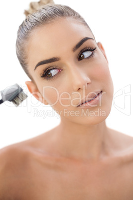 Concentrated woman looking at her make up brush