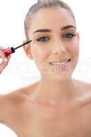 Happy woman applying mascara