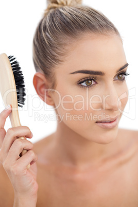 Serious woman holding a hairbrush