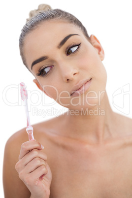 Serious woman looking at her toothbrush