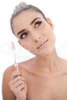 Thoughtful woman holding a toothbrush