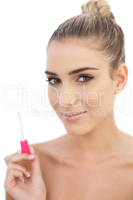 Pleased woman holding a gloss