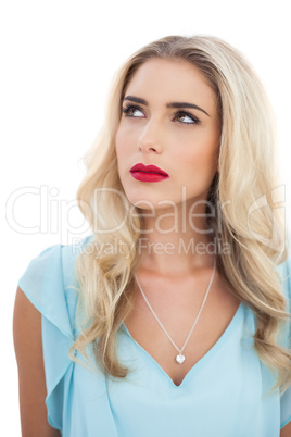 Thoughtful blonde model in blue dress looking away