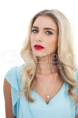 Thoughtful blonde model in blue dress looking at camera