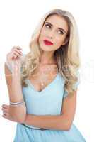 Seductive blonde model in blue dress looking away