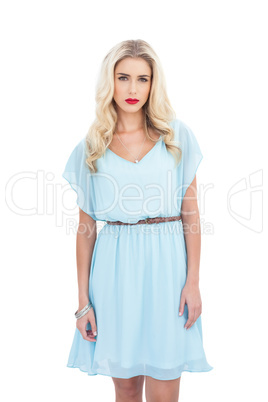 Charming blonde model in blue dress looking at camera