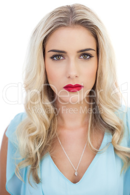 Portrait of a pensive blonde model in blue dress looking at came
