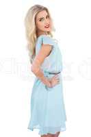 Pretty blonde model in blue dress posing hand on the hip