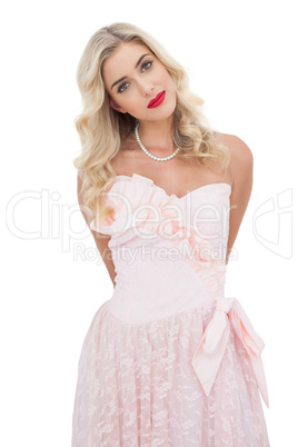Content blonde model in pink dress posing looking at camera