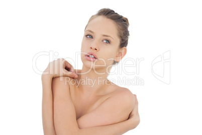 Concentrated brunette model posing holding her shoulders