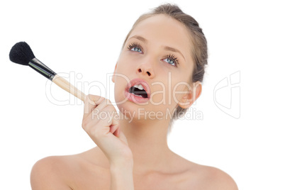 Cute brunette model holding a brush and looking away