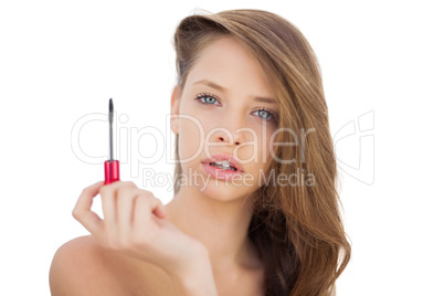 Serious brunette model holding a mascara tube