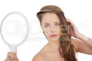 Calm brunette model posing holding a mirror