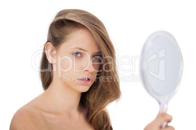 Attentive brunette model posing holding a mirror
