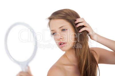 Calm brunette model posing looking herself in a mirror