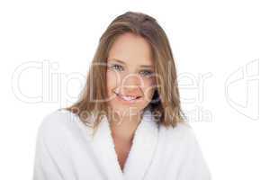 Smiling brunette in bathrobe looking at camera