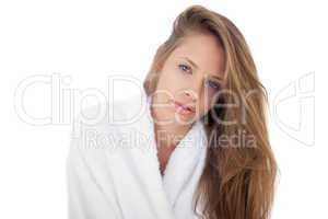 Pensive brunette in bathrobe looking at camera