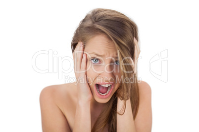 Afraid brunette model holding her head and screaming