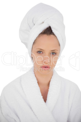 Serious brunette in bathrobe looking at camera