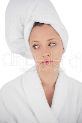 Thinking brunette in bathrobe looking away