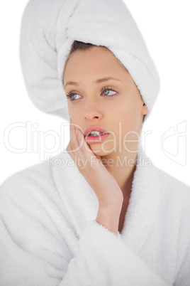 Serious brunette model in bathrobe looking away