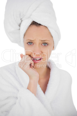 Worried brunette in bathrobe looking at camera