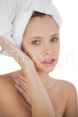 Thoughtful brunette drying her hair looking at camera