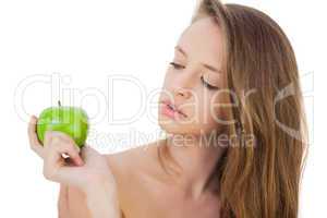 Thoughtful brunette model holding an apple