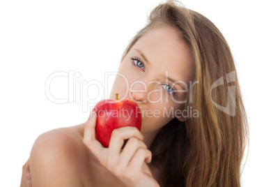 Pensive brunette model eating an apple