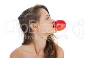 Calm brunette model holding an apple in her mouth